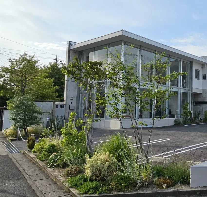 植栽を整えたふくい歯科医院の正面外観（背景加工画像）